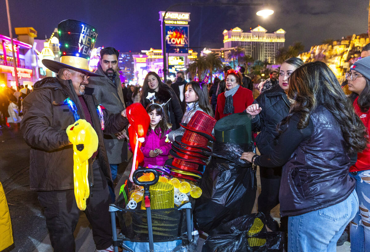 Ishmael Devora sells his holiday hats and other items near The Mirage on New Year’s Eve along ...