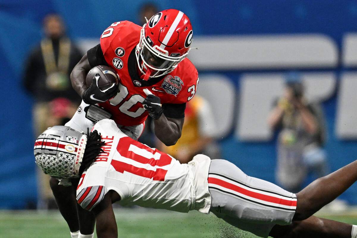 Georgia running back Daijun Edwards (30) runs into Ohio State cornerback Denzel Burke (10) duri ...