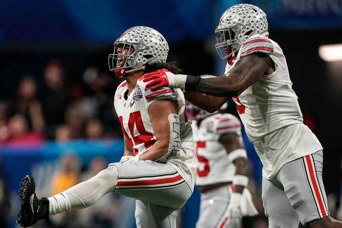 Ohio State defensive end J.T. Tuimoloau (44) and Ohio State defensive end Zach Harrison (9) cel ...