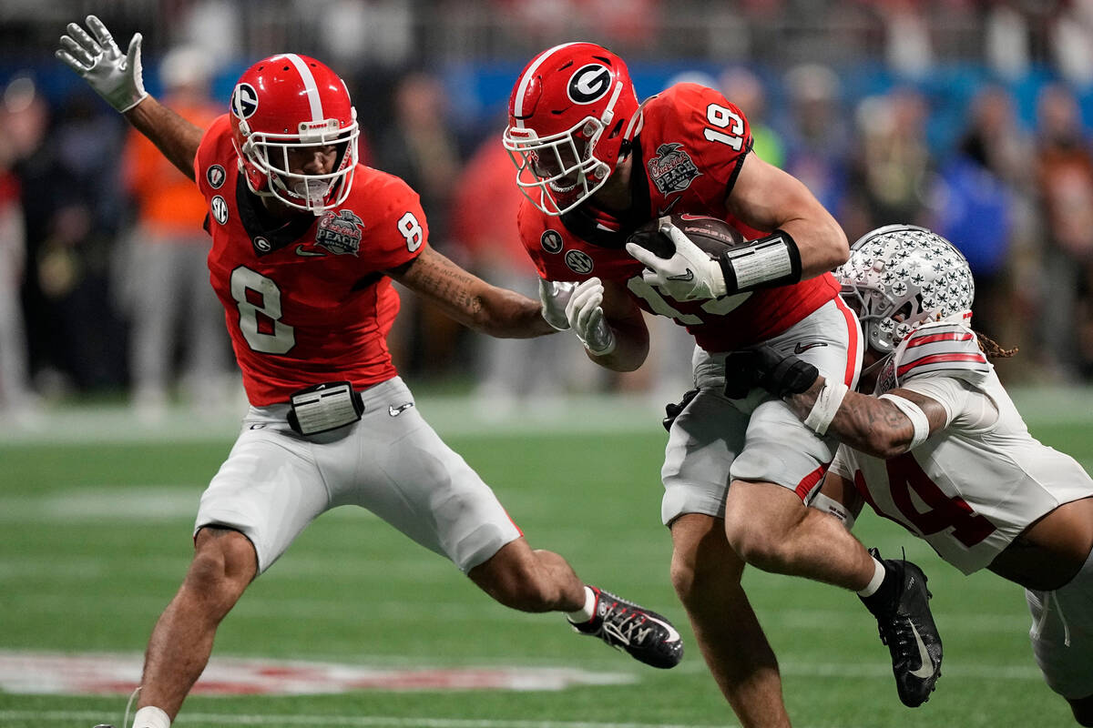 Ohio State safety Ronnie Hickman (14) hits Georgia tight end Brock Bowers (19) during the secon ...