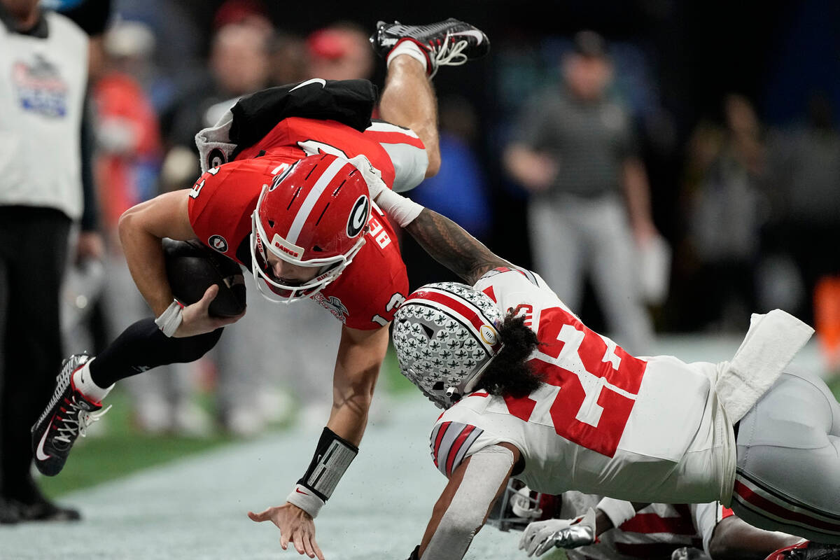 Georgia quarterback Stetson Bennett (13) leaps out of bounds against Ohio State during the firs ...