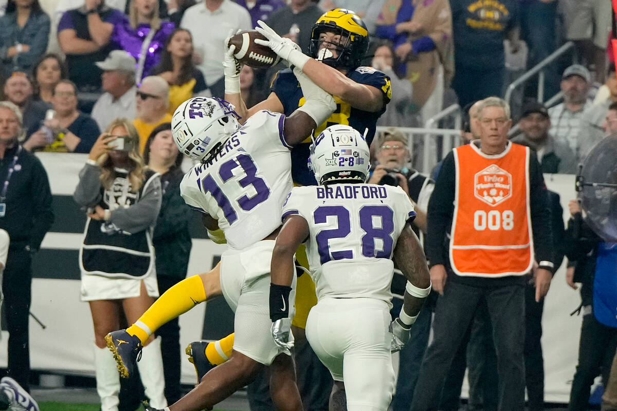 Michigan tight end Colston Loveland makes a catch as TCU linebacker Dee Winters (13) defends du ...