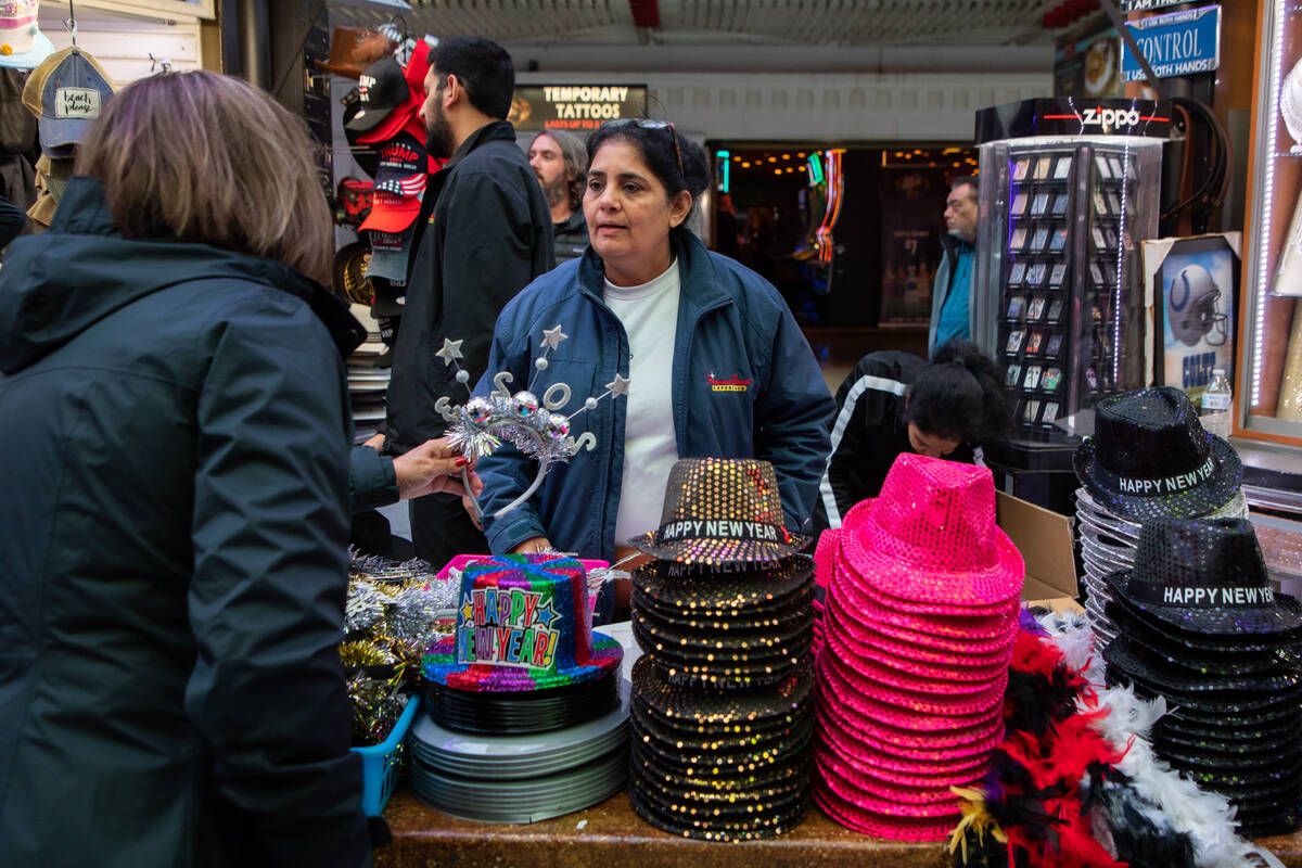 Taru Patel helps a customer at her booth selling New Year’s Eve gear on Saturday, Dec. 3 ...
