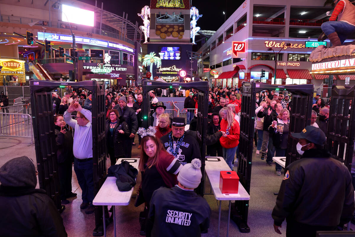 Revelers go through security on New Year’s Eve at the 4th Street entrance to the Fremont Stre ...