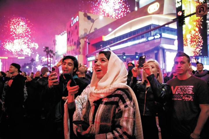 New Year’s Eve revelers watch the fireworks on the Strip on Saturday, Dec. 31, 2022. (Am ...