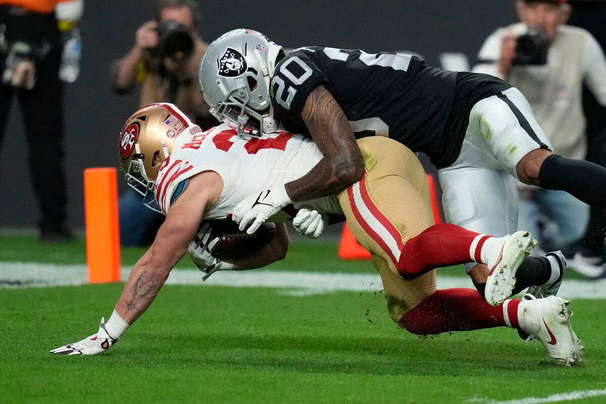 Las Vegas Raiders safety Isaiah Pola-Mao (20) tackles San Francisco 49ers running back Christia ...