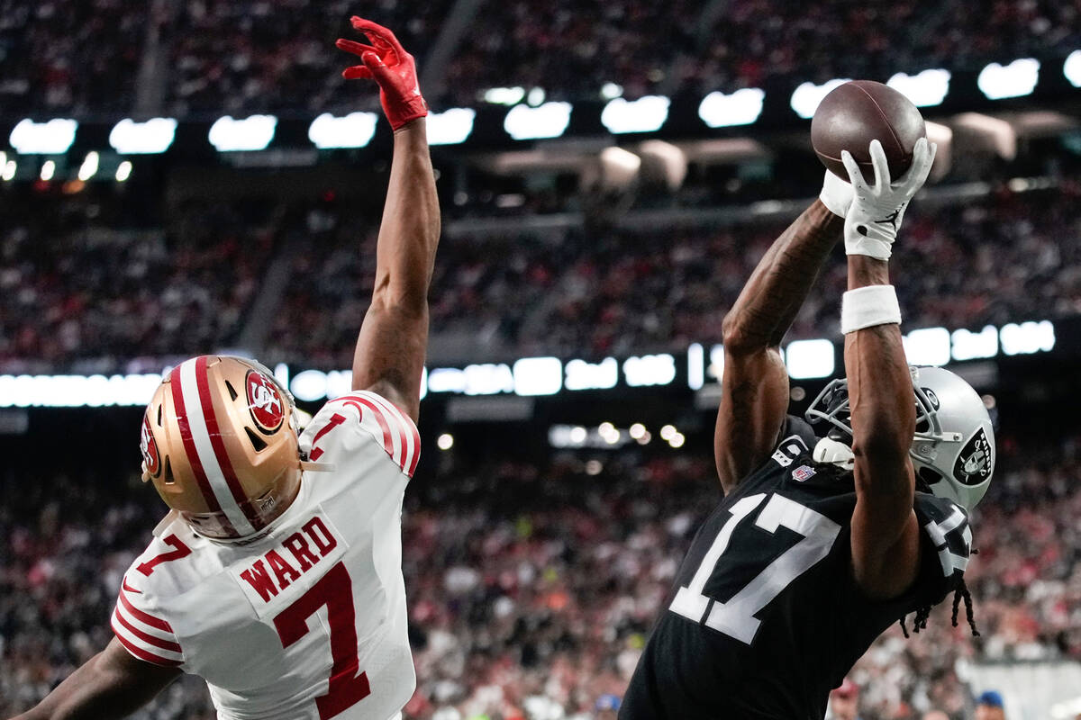 Las Vegas Raiders wide receiver Davante Adams (17) catches a four-yard touchdown pass while bei ...