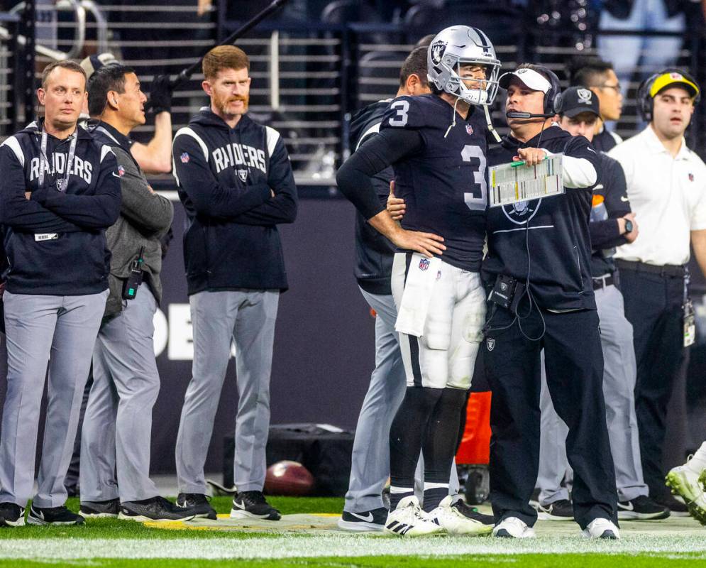 Raiders quarterback Jarrett Stidham (3) is counseled on the sidelines by Head Coach Josh McDani ...