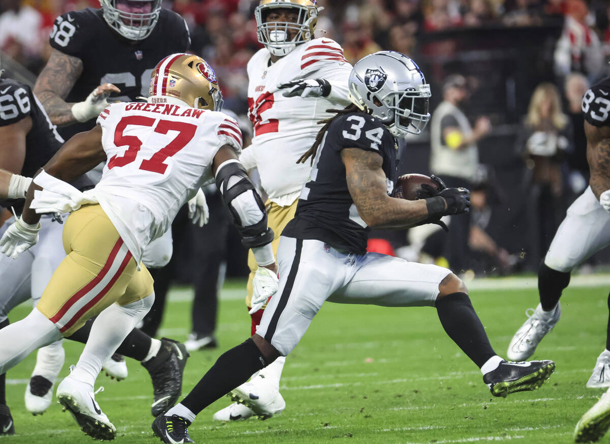 Raiders running back Brandon Bolden (34) runs the ball during the first half of an NFL game aga ...