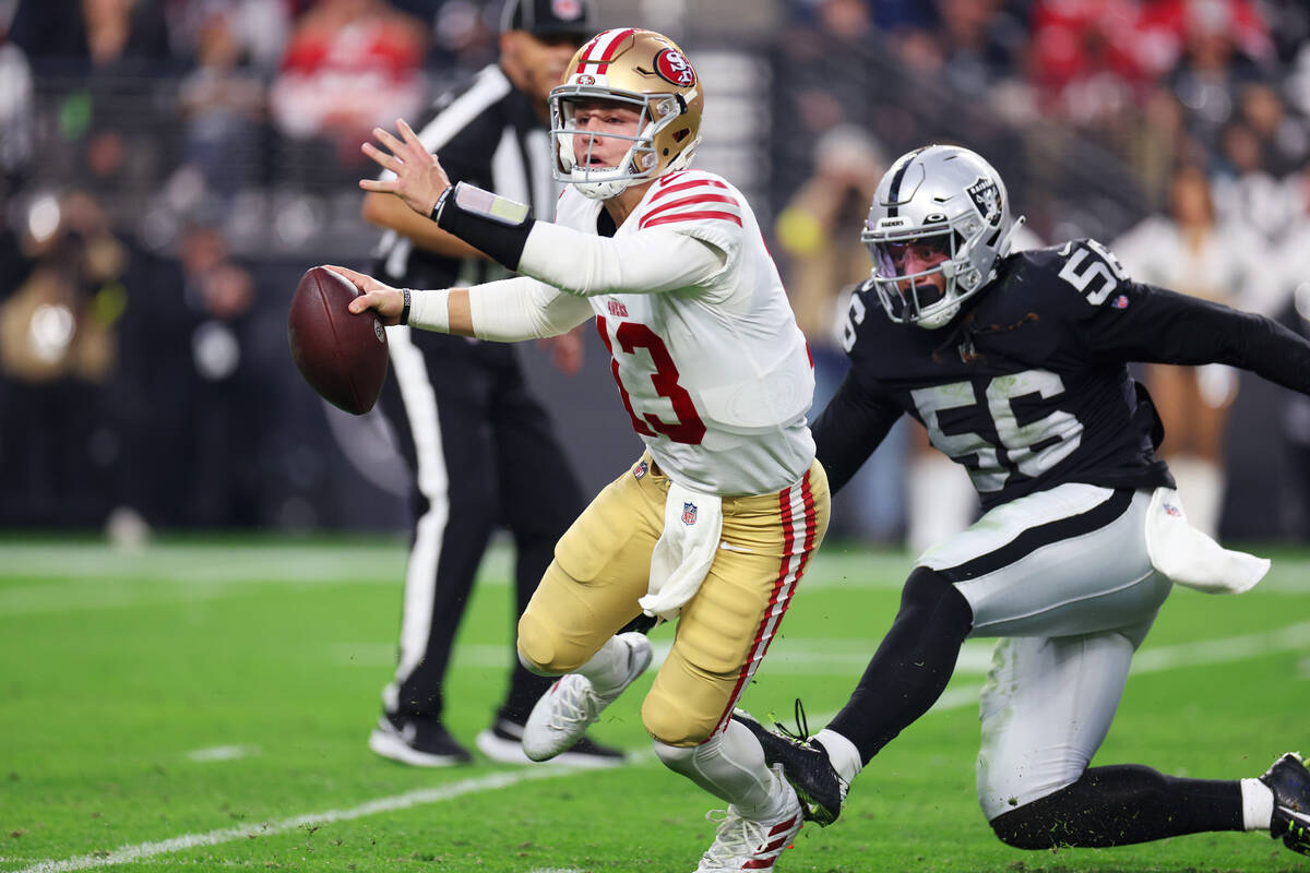 San Francisco 49ers quarterback Brock Purdy (13) avoids a tackle from Raiders linebacker Harvey ...