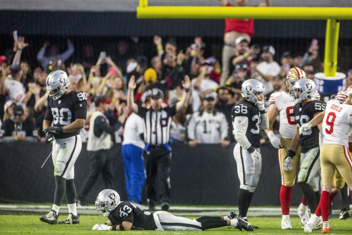 Raiders safety Roderic Teamer (33) lies dejected on the turf amongst teammates as the San Franc ...