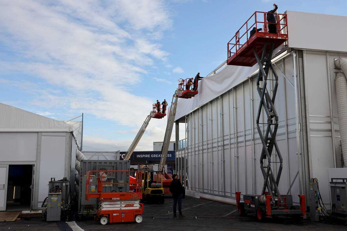 Workers build outdoor booths for CES at the Las Vegas Convention Center Tuesday, Jan. 3, 2023. ...