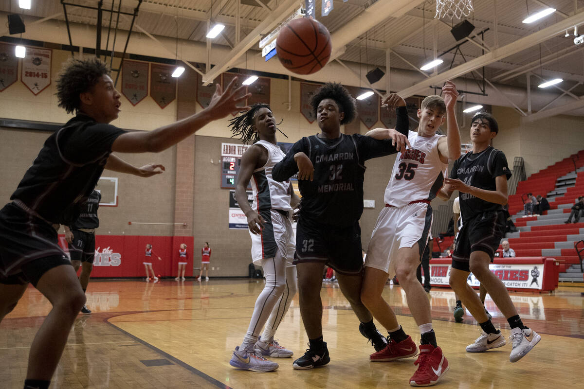 Cimarron-Memorial’s Jesse Judkins, left, receives a rebound pass from teammate Gerald Pa ...