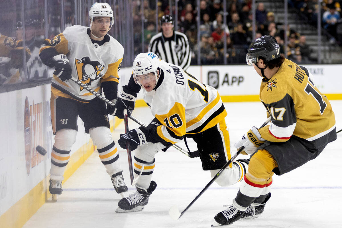 Pittsburgh Penguins left wing Drew O'Connor (10) passes the puck while Vegas Golden Knights def ...