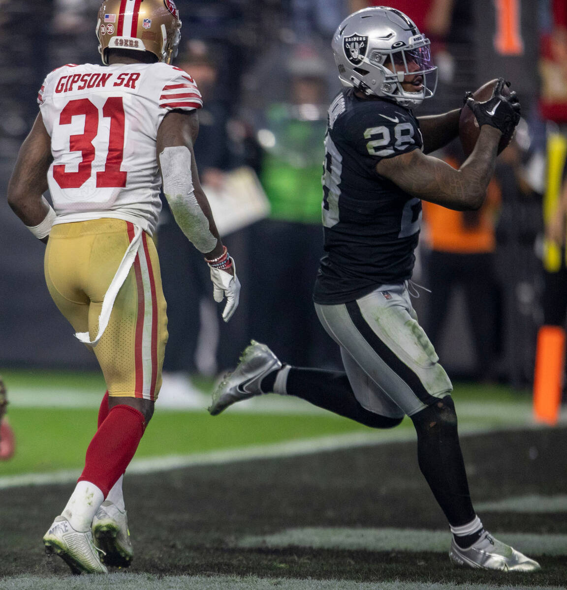 Raiders running back Josh Jacobs (28) scores a touchdown with San Francisco 49ers safety Tashau ...