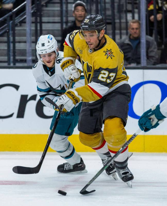 Golden Knights defenseman Alec Martinez (23) looks to the puck with San Jose Sharks center Stev ...