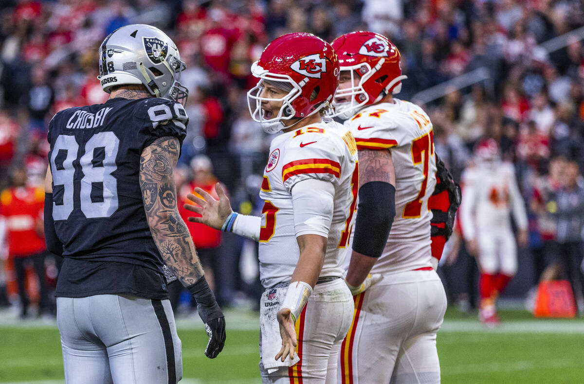 Kansas City Chiefs quarterback Patrick Mahomes (15) and Raiders defensive end Maxx Crosby (98) ...