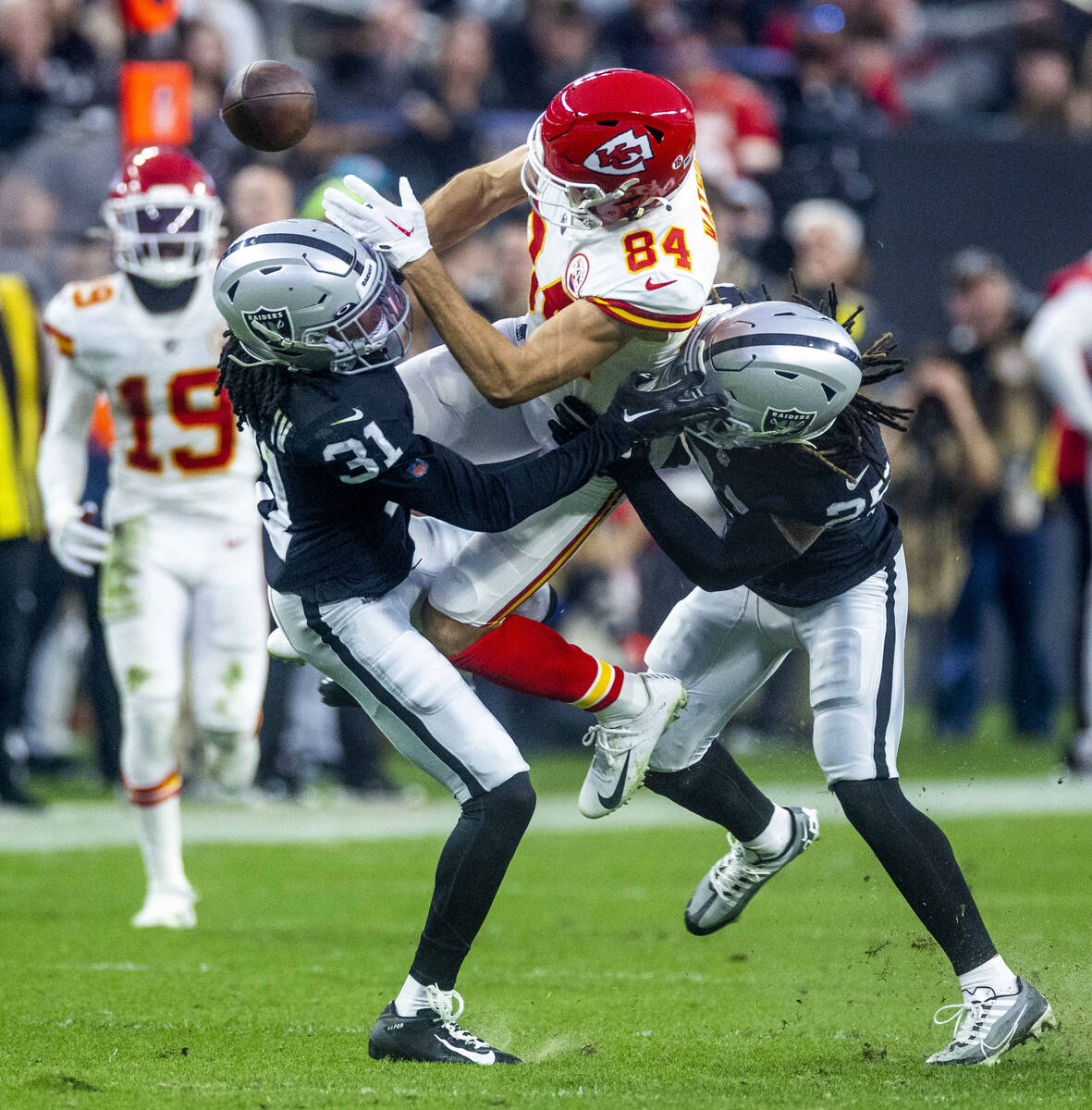 Raiders cornerback Sidney Jones IV (31) and safety Tre'von Moehrig (25) team cup to break up a ...