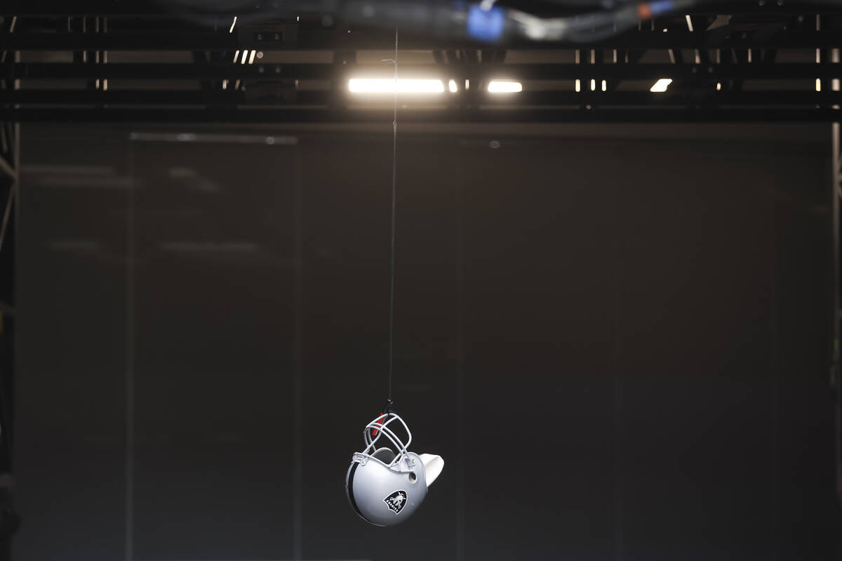 A fan dangles a helmet from the stands before an NFL game between the Raiders and Kansas City C ...