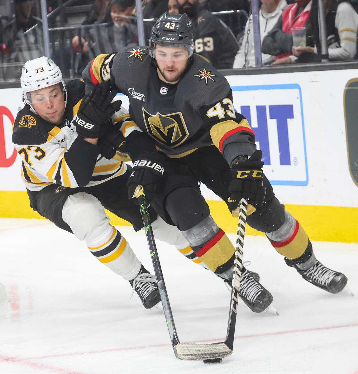 Golden Knights center Paul Cotter (43) guides the puck under pressure from Boston Bruins defens ...