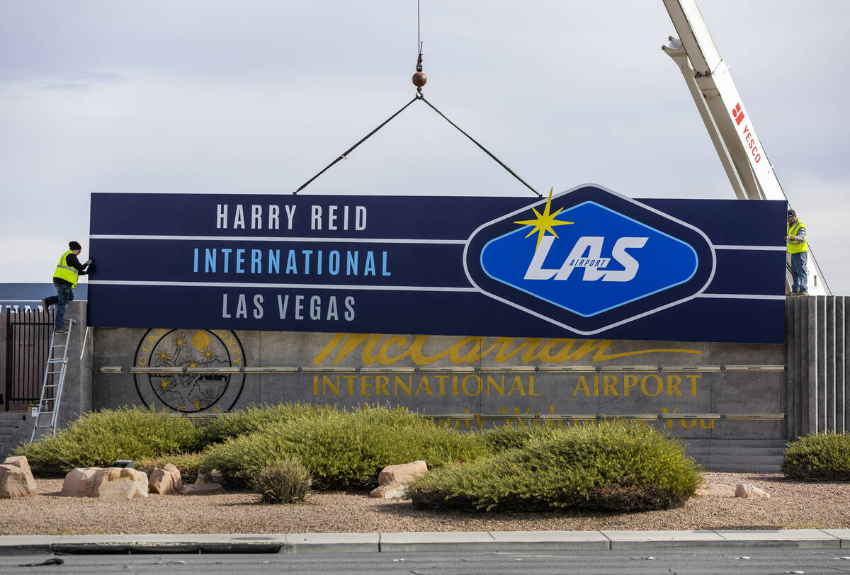 Workers from YESCO change the signage from McCarran International Airport to Harry Reid at Kova ...