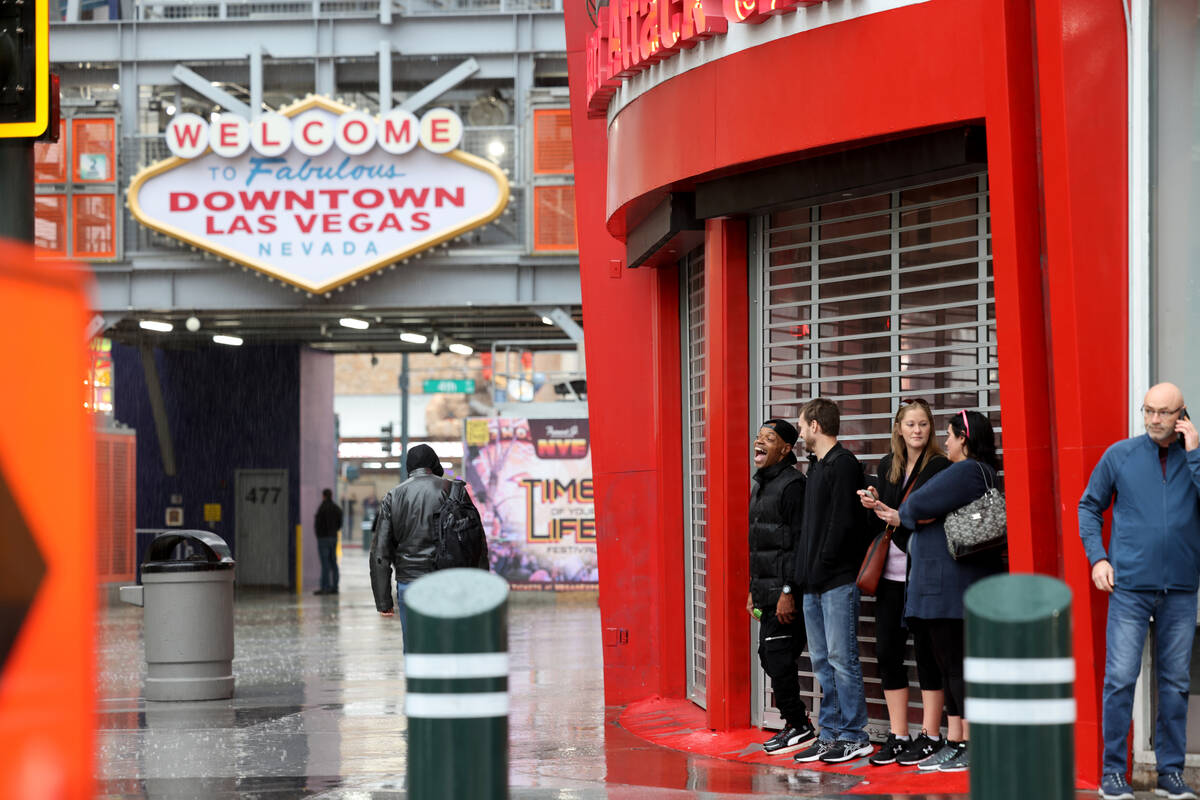 People take shelter from the rain at Las Vegas Boulevard and Fremont Street in Las Vegas Tuesda ...