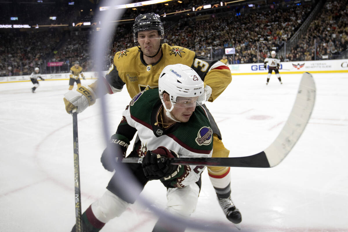 Golden Knights defenseman Brayden McNabb (3) is about to slam Coyotes defenseman Conor Timmins ...