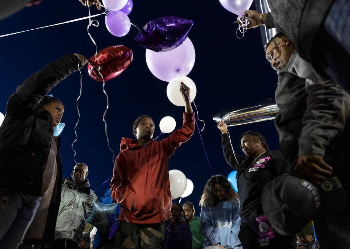 Ashari Hughes’ mother Twayne Hughes, second from right, and father, Enttroda Hughes, right, p ...