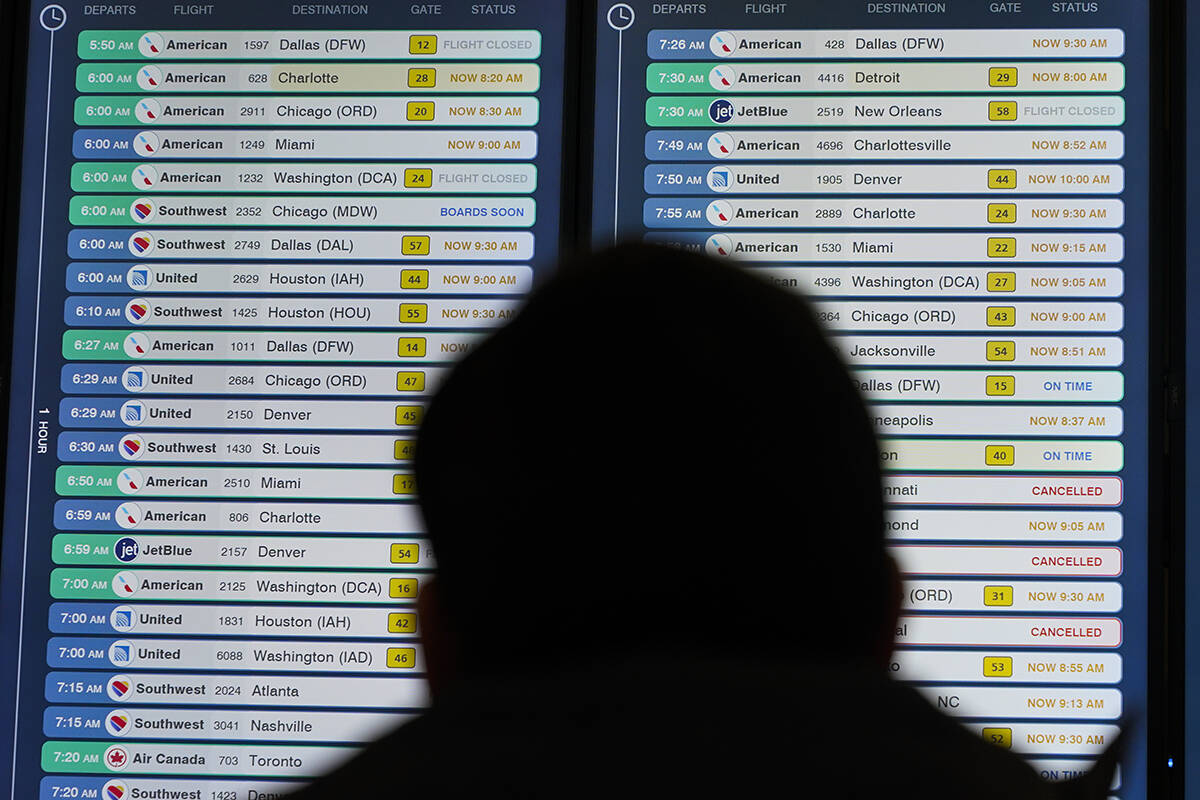 A display shows flights, many delayed, at LaGuardia Airport in New York, Wednesday, Jan. 11, 20 ...