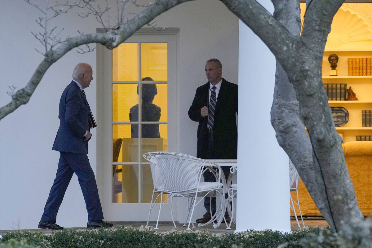 President Joe Biden, left, walks to the Oval Office on the South Lawn of the White House in Was ...