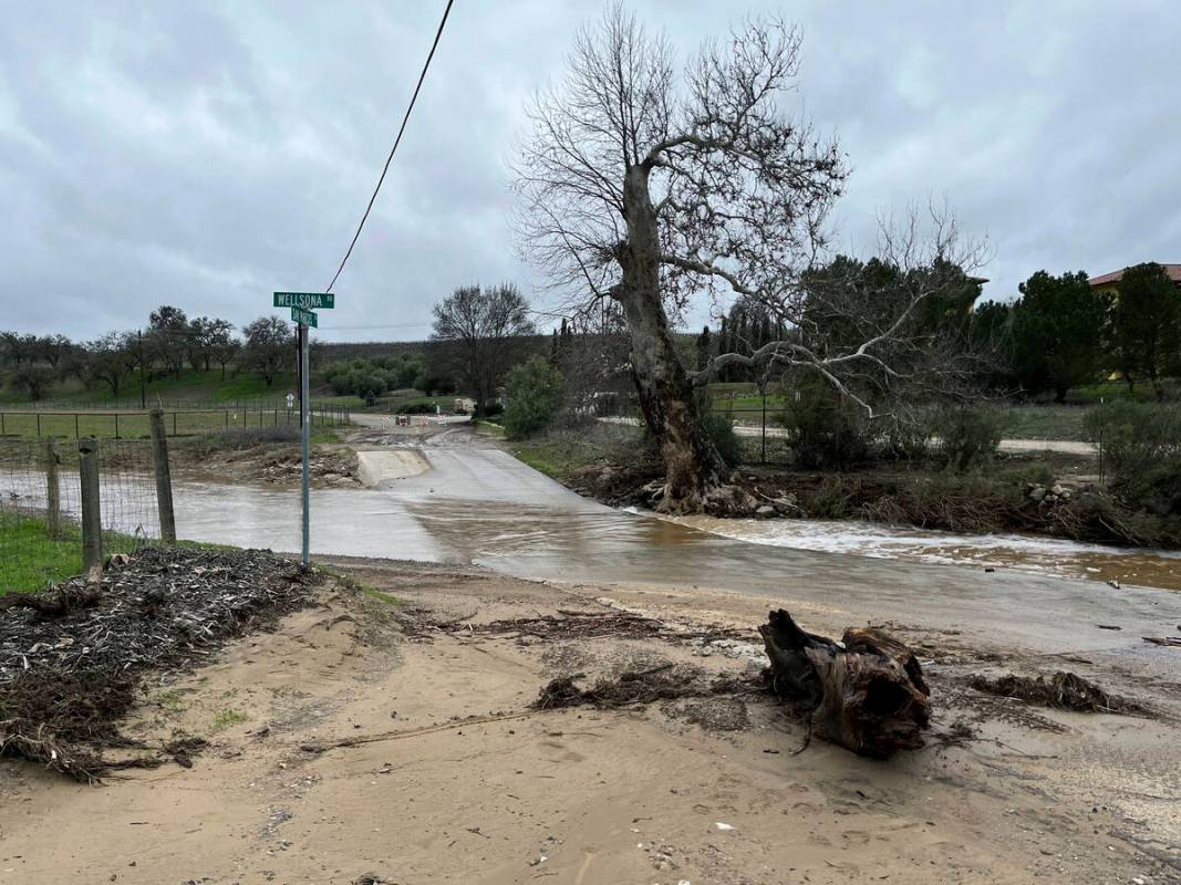 In this photo provided by Neil Collins, rain flows at the intersection of Wellsona Rd. and San ...