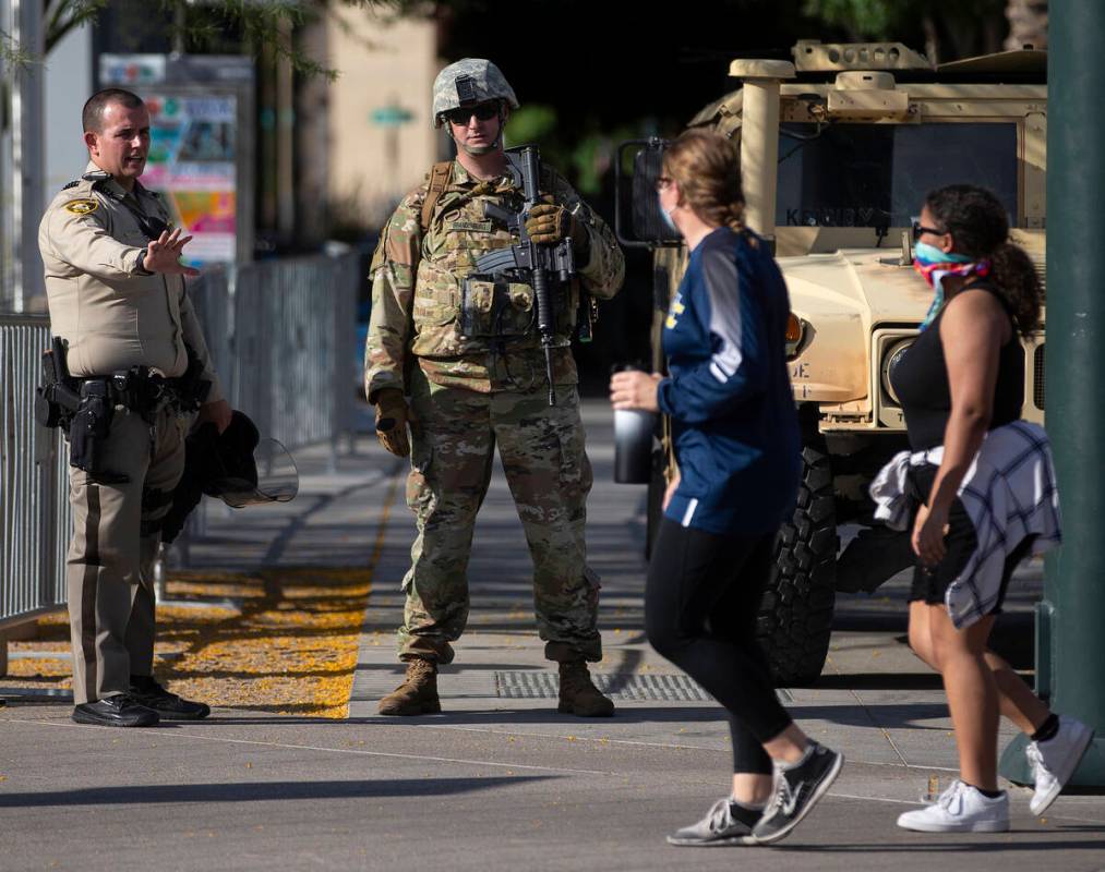 Protesters walk past law enforcement outside Las Vegas City Hall on Wednesday, June 3, 2020, in ...