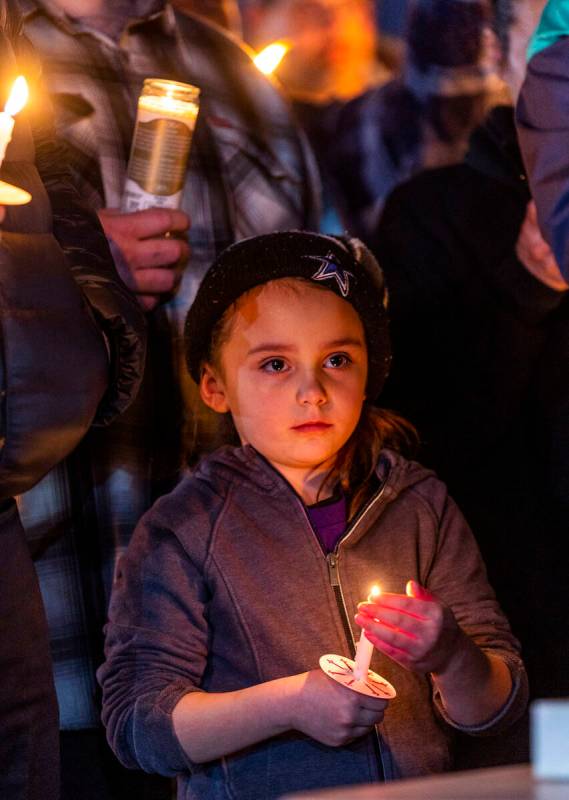 A child holds a candle as they and others honor Jonet Dominguez during a candlelight vigil at A ...