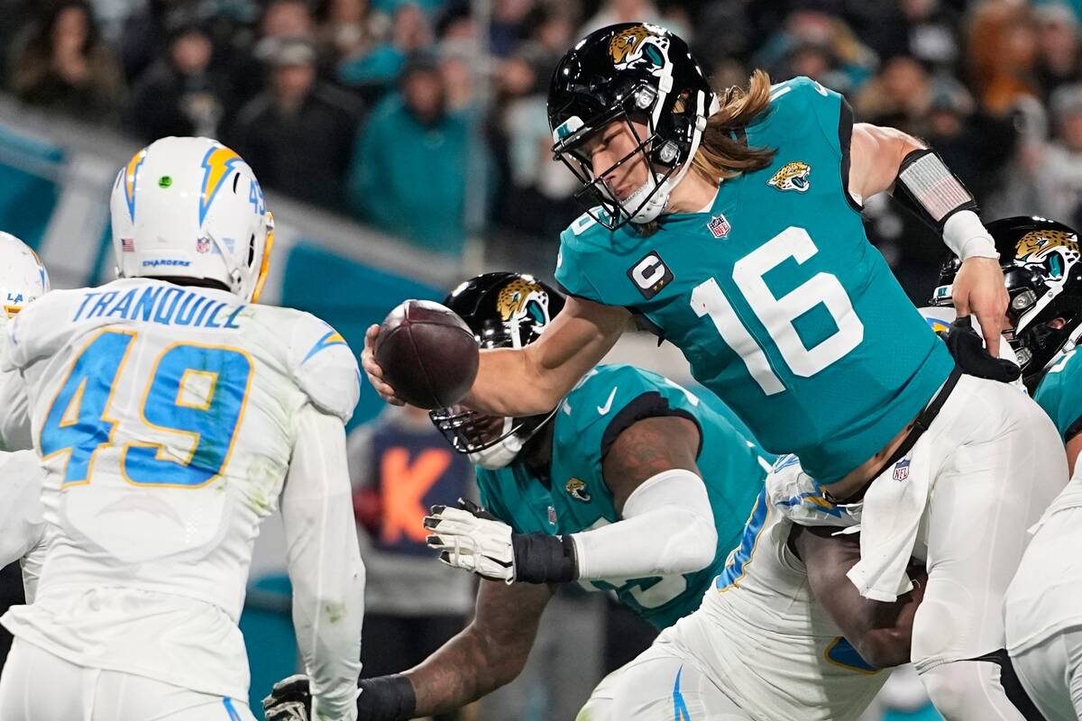 Jacksonville Jaguars quarterback Trevor Lawrence (16) leaps for a two-point conversion against ...