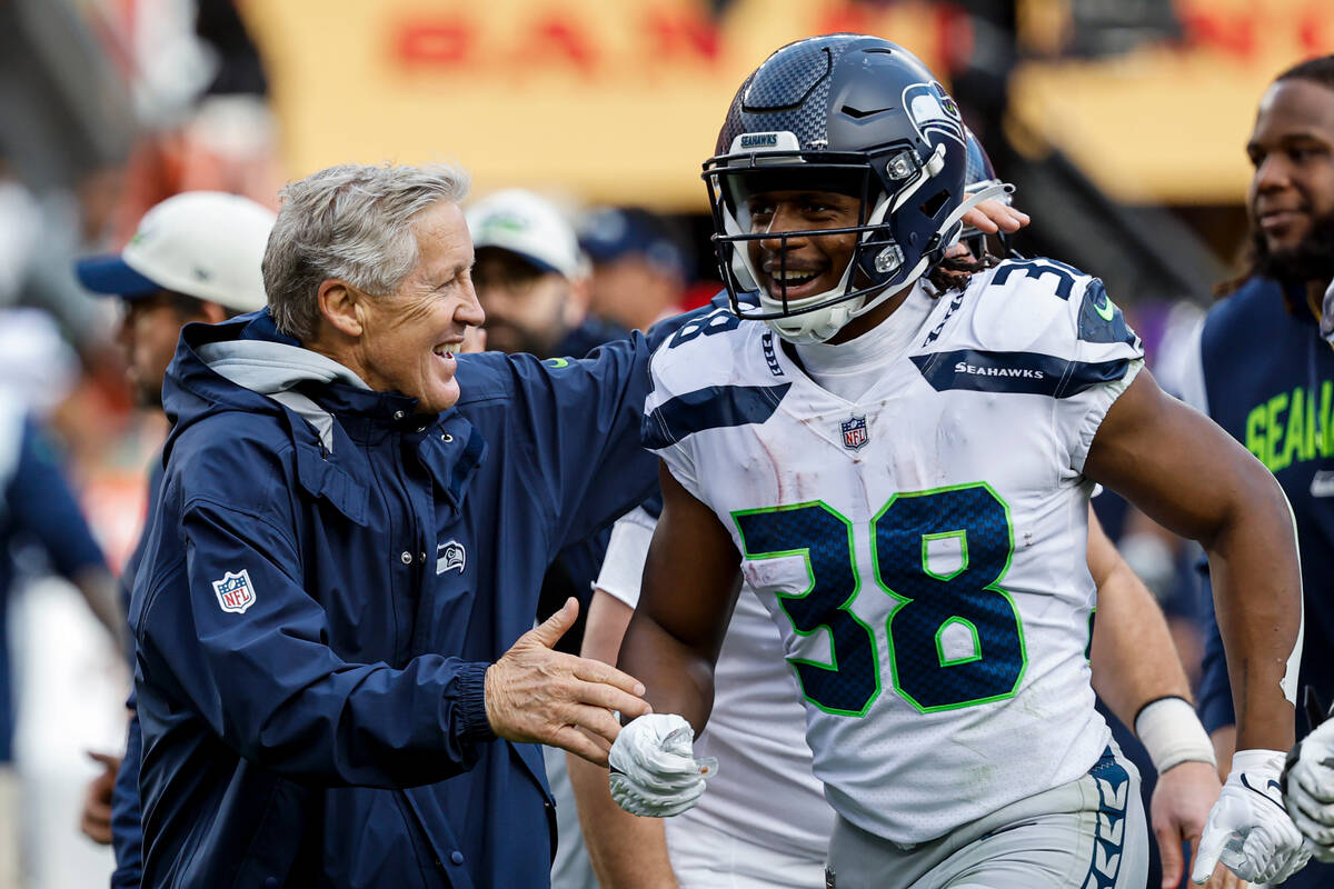 Seattle Seahawks head coach Pete Carroll, left, and Godwin Igwebuike (38) celebrate after place ...