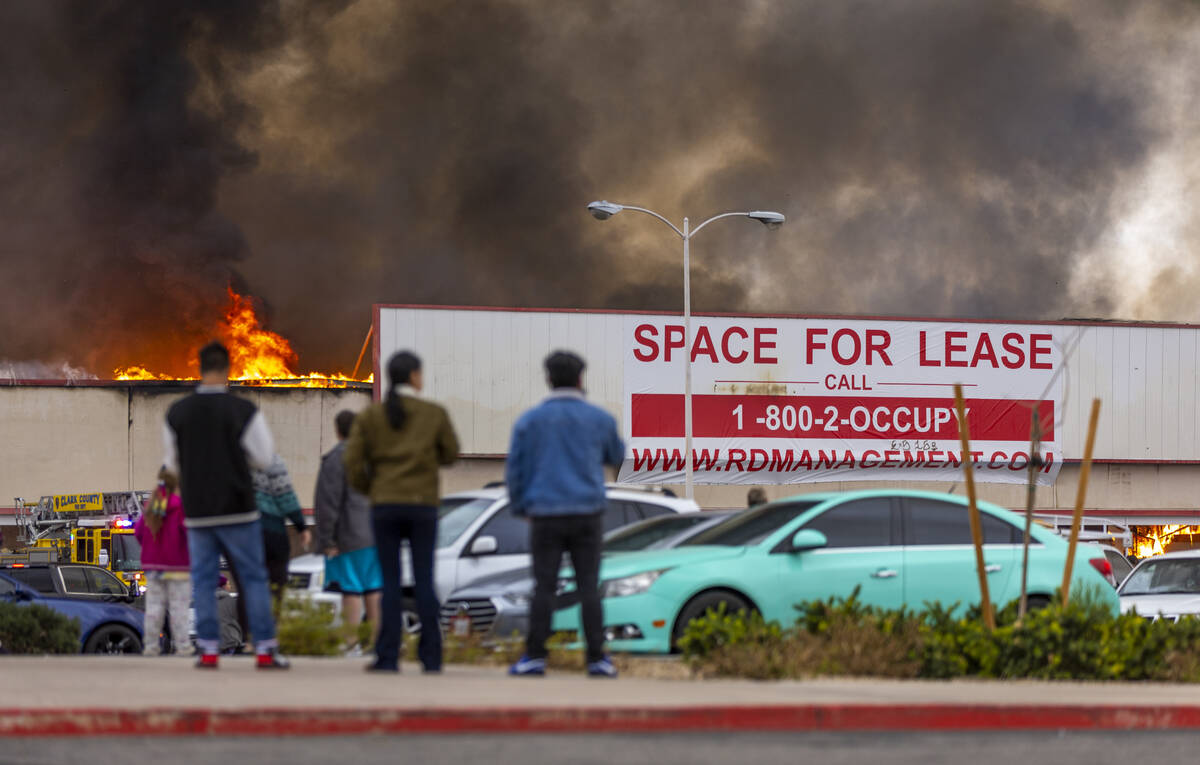 Onlookers watch as black smoke and flames rise into the sky while Las Vegas and Clark County Fi ...