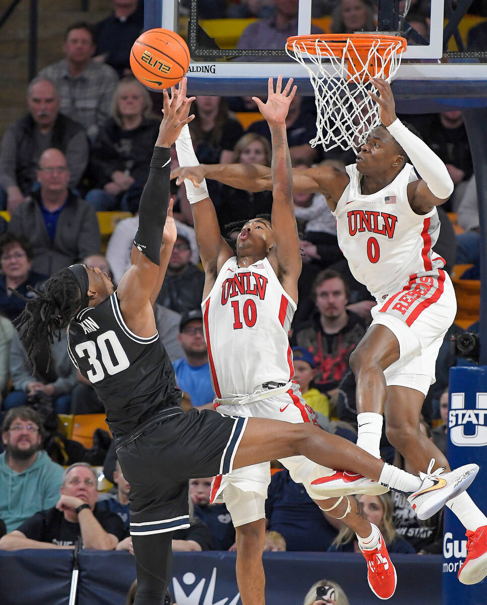 Utah State forward Dan Akin (30) shoots the ball as UNLV guard Keshon Gilbert (10) and forward ...