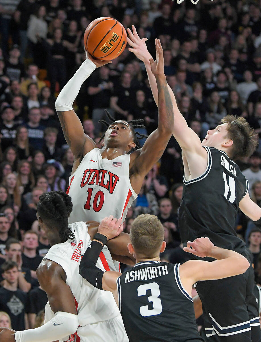 UNLV guard Keshon Gilbert (10) takes a shot as Utah State guard Max Shulga (11) defends during ...