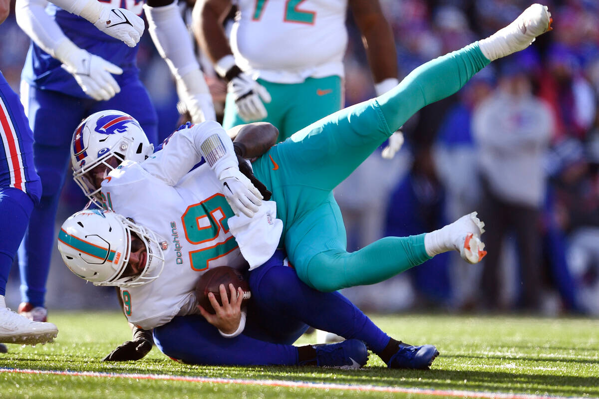 Miami Dolphins quarterback Skylar Thompson (19) is taken down by Buffalo Bills defensive end Bo ...