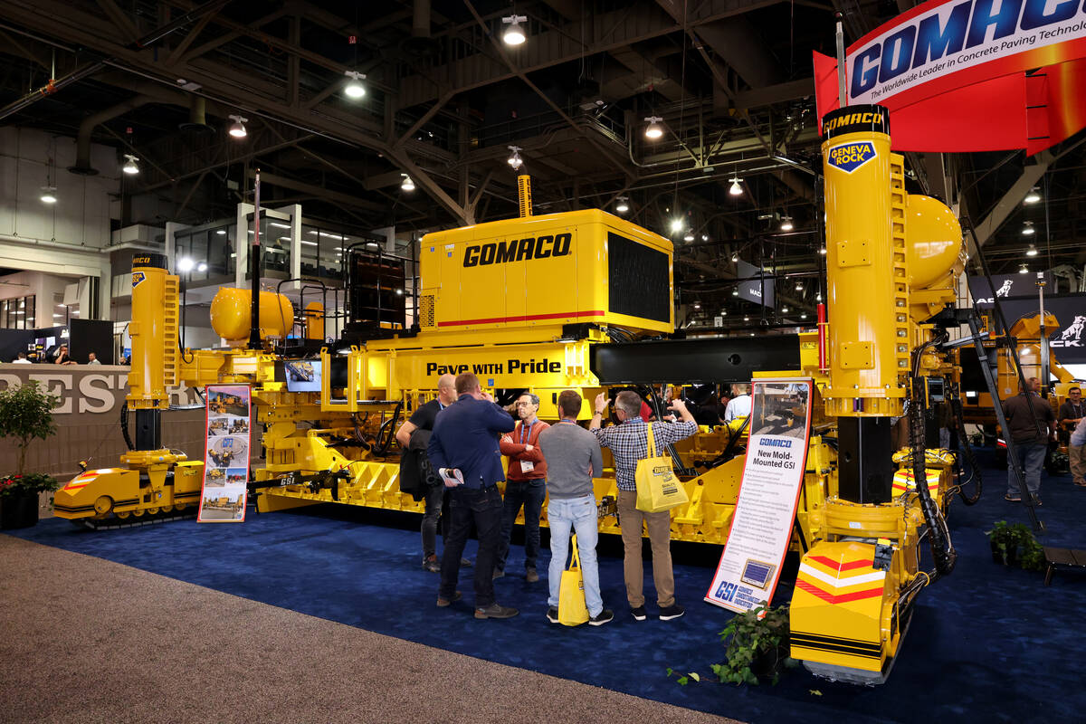 Conventioneers check out a concrete slipform paver used to make roads in the Gomaco booth on Da ...