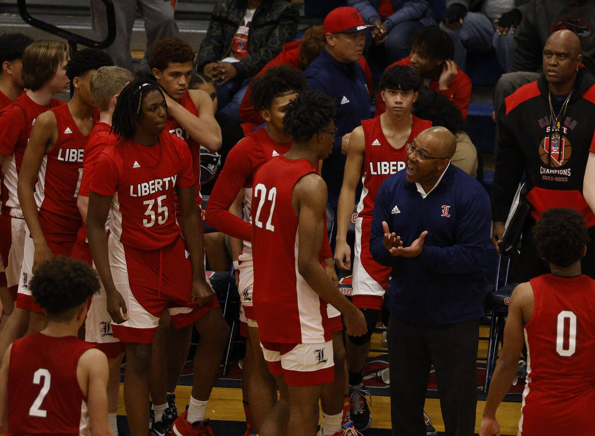 Liberty head coach Kevin Soares speaks to his players during the second half of a basketball ga ...