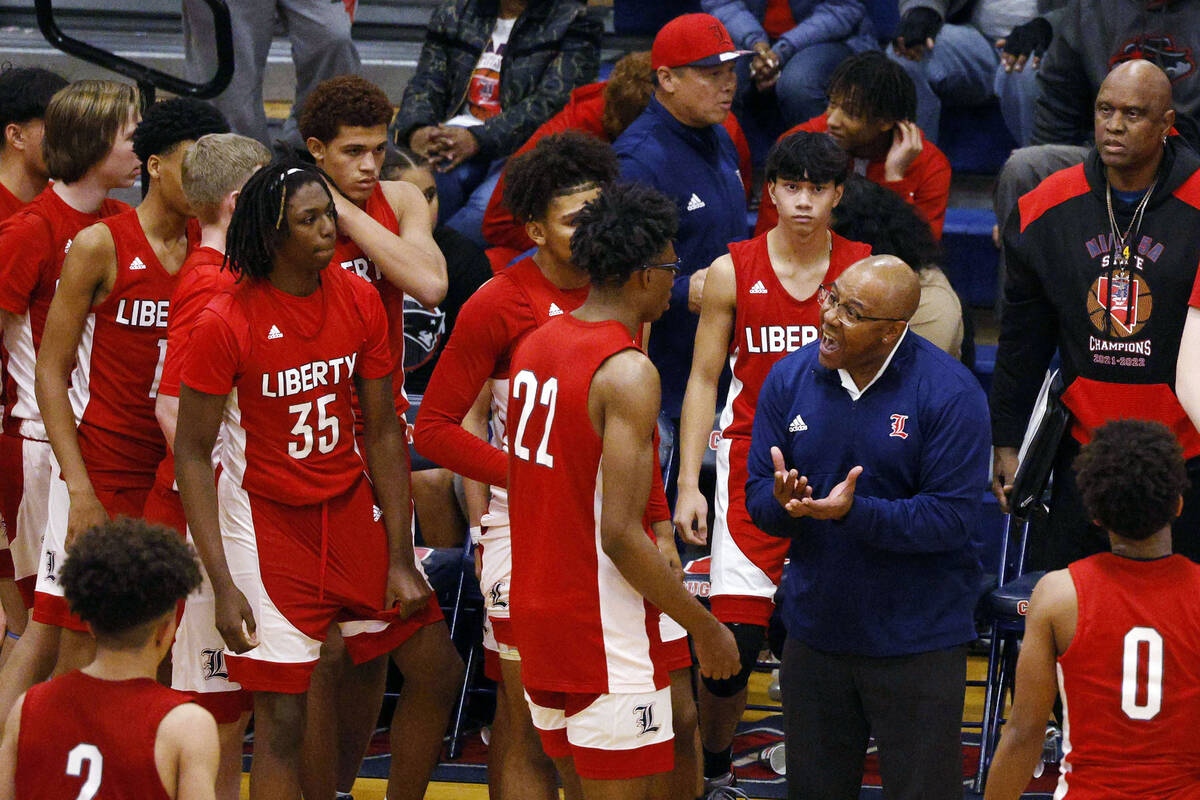 Liberty head coach Kevin Soares speaks to his players during the second half of a basketball ga ...