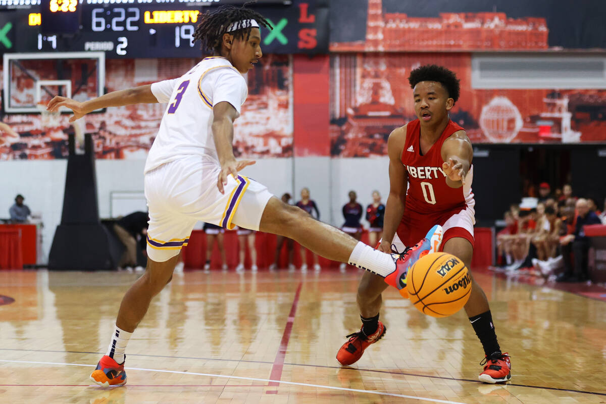 Liberty's Tyus Thomas (0) makes a pass under pressure from Durango's Jevon Yapi (3) during the ...