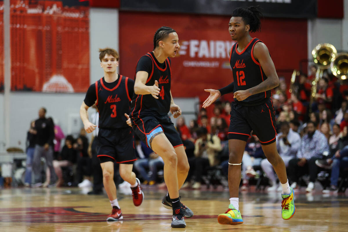 Coronado's Sebastian Mack (12) celebrates a basket with JC Brooks (4) during the first half of ...