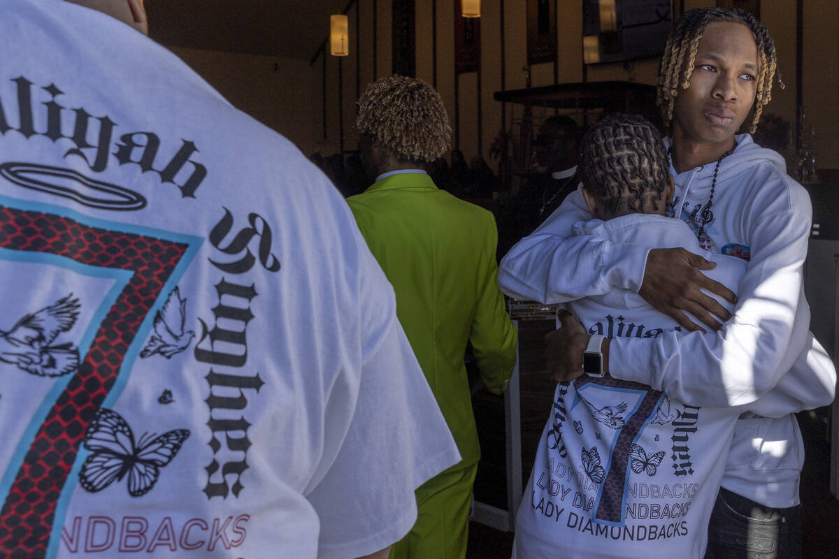 Enttroda Hughes Jr. and Josiah Hughes, brothers of Ashari Hughes, embrace as their sister&#x201 ...