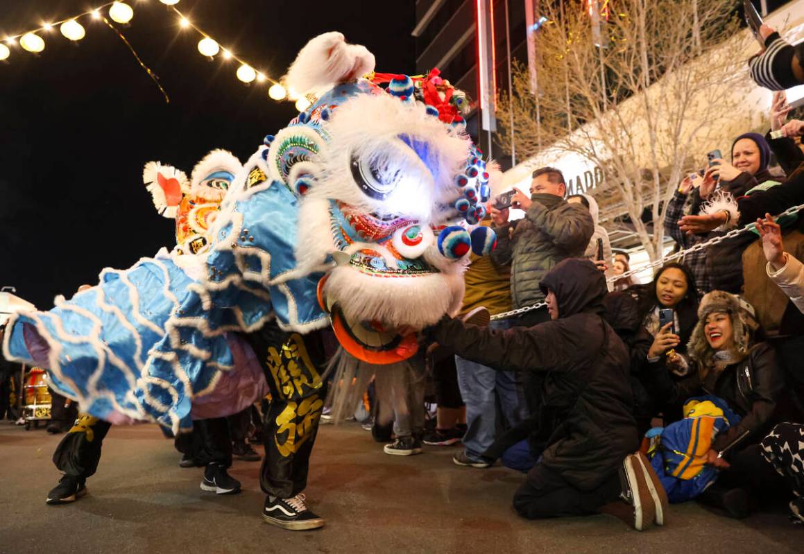 Members of Guan Strong Lion Arts get up close with the crowd during a lion dance during Downtow ...