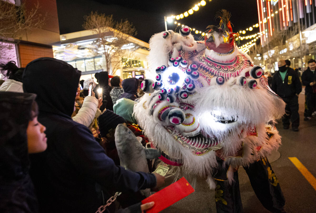 Members of Guan Strong Lion Arts get up close with the crowd during a lion dance during Downtow ...