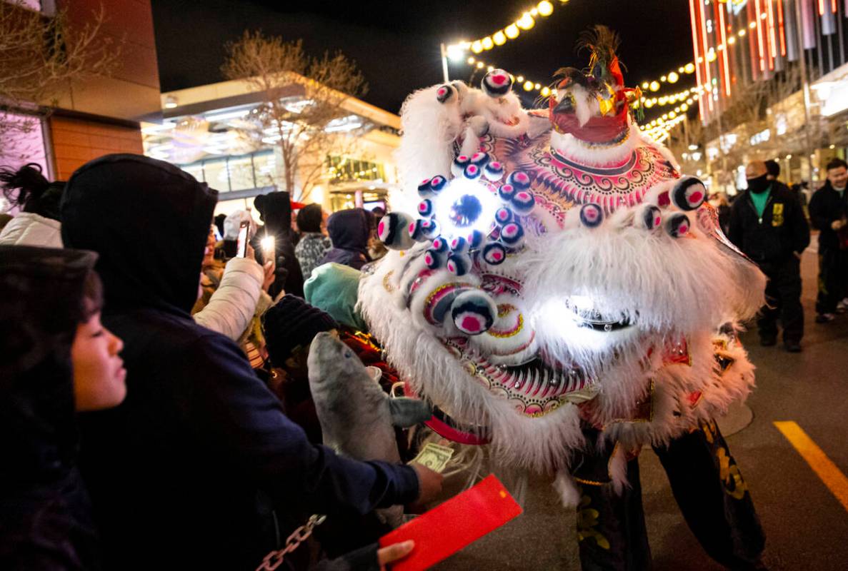 Members of Guan Strong Lion Arts get up close with the crowd during a lion dance during Downtow ...