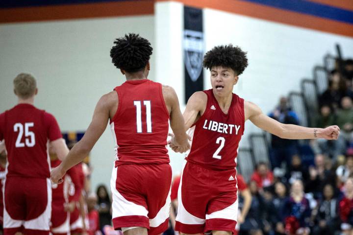 Liberty’s Angelo Kambala (2) slaps hands with his teammate Dedan Thomas Jr. (11) during ...