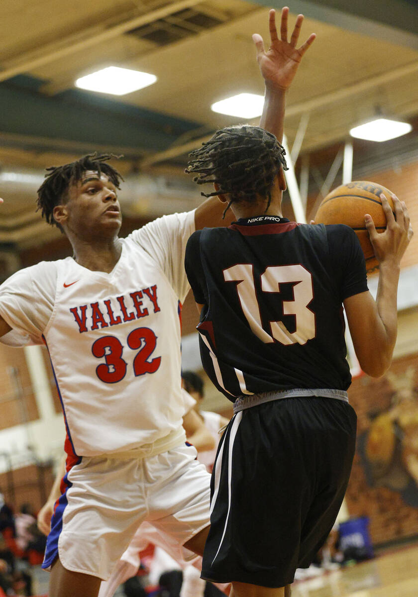 Desert Oasis' Kaden Arnold (13) looks to pass against Valley's Xavier Shufford (32) during the ...